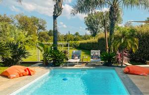 a swimming pool in a yard with two chairs at Très Beau Gîte Piscine - Spa in Solliès-Pont