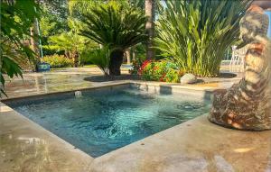 a swimming pool with a statue in the middle of a yard at Très Beau Gîte Piscine - Spa in Solliès-Pont