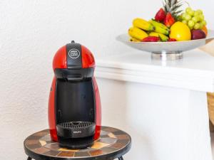 a red and black blender sitting on a table with a bowl of fruit at 1316 Paraiso Sur, Amazing view in Playa Paraiso