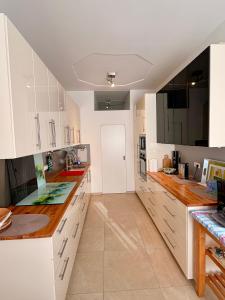 a kitchen with white cabinets and wooden counter tops at FeWo Altes Doktorhaus in Berchtesgaden