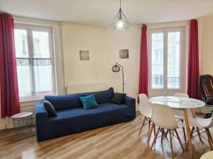 a living room with a blue couch and a table at Frégate in Cherbourg en Cotentin