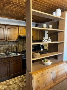a kitchen with wooden cabinets and a sink at Gemütliche Ferienwohnung mit Blick ins Grüne in Zwiesel +2 photos