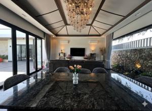 a living room with a table and chairs and a chandelier at Somnea Villa in Kampot