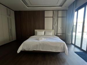 a bedroom with a large white bed and a large window at Somnea Villa in Kampot +14 photos