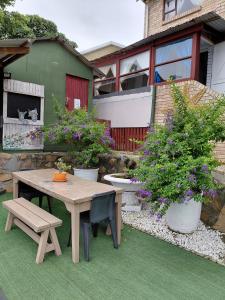 a patio with a table and benches and potted plants at Rusibiki in Gqeberha