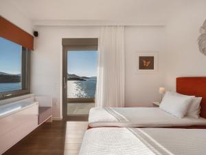 a bedroom with a bed and a view of the ocean at SK Place Luxury Seafront Villas Chania in Almyrida +89 photos