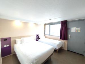 a hotel room with two beds and a window at Kyriad Meaux Sud Nanteuil Les Meaux in Nanteuil-lès-Meaux