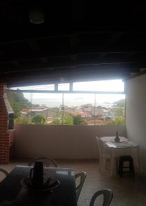 a room with a table and a large window at 500 metros da praia in Governador Celso Ramos +23 photos