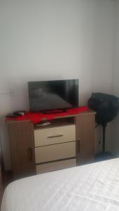 a bedroom with a bed and a tv on a desk at 500 metros da praia in Governador Celso Ramos