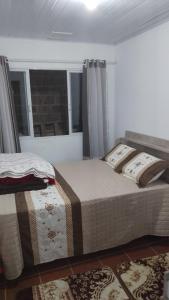 a bedroom with two beds and a window at 500 metros da praia in Governador Celso Ramos