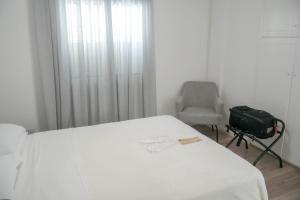 a room with a bed and a chair and a suitcase at Athalassas corner in Strovolos