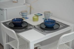 a white table with two blue cups and plates on it at Athalassas corner in Strovolos +15 photos
