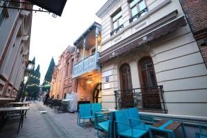 a group of blue chairs and tables on a street at Hotel Nicolo in Tbilisi City