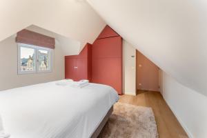 a bedroom with a white bed and a window at stijlvol appt met adembenemend uitzicht op het centrum van Ieper in Ieper