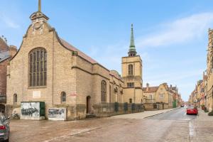 a large brick church with a steeple on a street at stijlvol appt met adembenemend uitzicht op het centrum van Ieper in Ieper