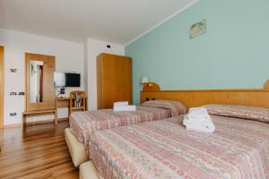 a hotel room with two beds and a television at Hotel Spera in Strigno +85 photos