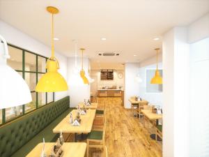 a restaurant with wooden tables and yellow pendants at Bloom Hotel - ISKCON Rajajinagar in Bangalore +22 photos