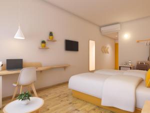 a bedroom with two beds and a desk with a computer at Bloom Hotel - ISKCON Rajajinagar in Bangalore