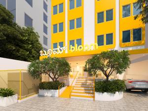 a yellow and white building with a staircase at Bloom Hotel - ISKCON Rajajinagar in Bangalore