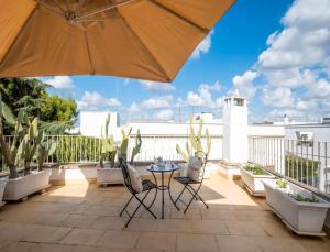a patio with a table and chairs and an umbrella at Corte Aragonese Suite Spa Privata in Veglie