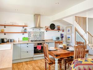 a kitchen and dining room with a wooden table at The Cheese Loft in Drummore