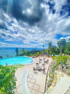a pool with chairs and a view of the ocean at My Honey's Farm in Nangkaan