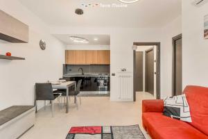 a living room with a red couch and a kitchen at Cà del Magra, TerreMarine in Santo Stefano di Magra