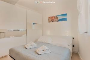 a white bedroom with a bed with two towels on it at Cà del Magra, TerreMarine in Santo Stefano di Magra