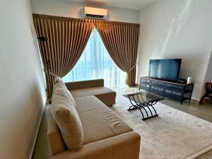 a living room with a couch and a television at Almyra cozy condo in Kajang