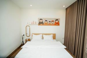 a bedroom with a large bed with white sheets at Dimori homestay in Hue