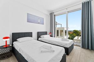 two beds in a room with a large window at Levanda Hills Haven in Protaras in Paralimni +37 photos