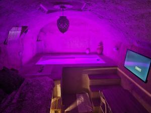 a purple room with a tub and a tv at Il Casale dei Principi in Lecce