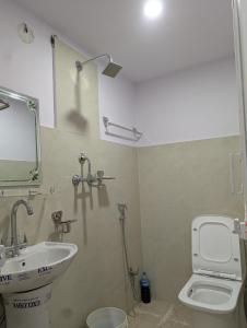 a bathroom with a sink and a toilet and a mirror at Hotel New Airport in Kathmandu