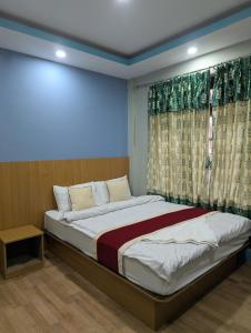 a bedroom with a large bed with a window at Hotel New Airport in Kathmandu