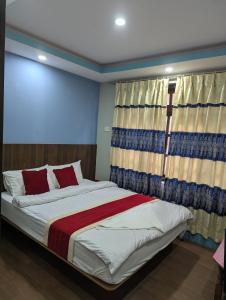 a bedroom with a large bed with a window at Hotel New Airport in Kathmandu