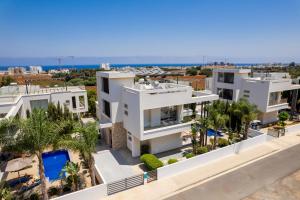 an aerial view of a white apartment building with palm trees at Levanda Hills Haven in Protaras in Paralimni