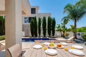 a table with food and drinks on a patio at Levanda Hills Haven in Protaras in Paralimni