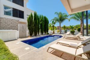 a villa with a swimming pool and patio furniture at Levanda Hills Haven in Protaras in Paralimni
