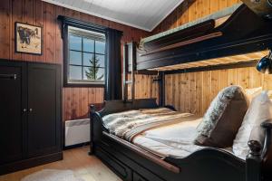a bedroom with a large bed in a room with wooden walls at TH589- Large ski-in out chalet in Trysilfjell with sauna, hottub in Hovi