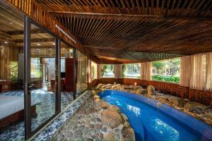 a house with a swimming pool in the middle of a room at Hang Mua Ecolodge in Ninh Binh