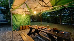a picnic table under an umbrella with food on it at Gapyeong Karabankaempingnongwon in Gapyeong