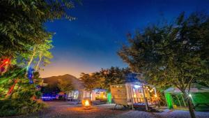 a row of tiny homes at night at Gapyeong Karabankaempingnongwon in Gapyeong