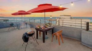 a table and chairs with umbrellas on the beach at Gangneung Glad Pension in Gangneung +5 photos