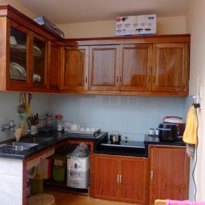 a kitchen with wooden cabinets and a counter top at Homestay A1 in Diện Biên Phủ