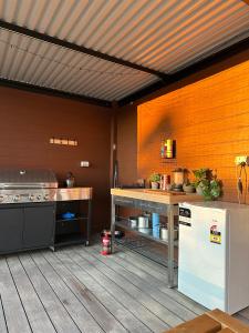 a large kitchen with a counter and a refrigerator at Romantic Stargazing Getaway - Beyond Bubbles in Kanimbla