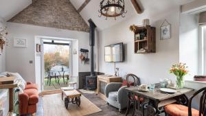 a living room with a table and a fireplace at Filly Island in South Cerney