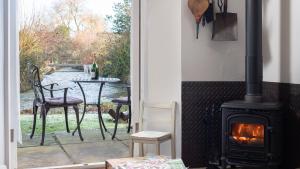 a patio with a stove and a table with chairs at Filly Island in South Cerney