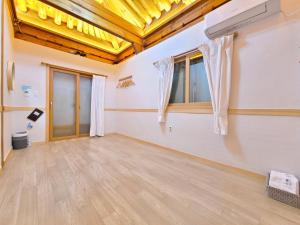an empty room with a yellow ceiling and wooden floors at 나들한옥 한옥스테이 in Gyeongju