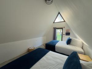 a attic bedroom with two beds and a window at Arena Hostel in El Paredón Buena Vista