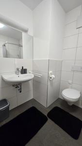 a white bathroom with a sink and a toilet at Wirt zSeifriedswörth in Wurmsham +4 photos